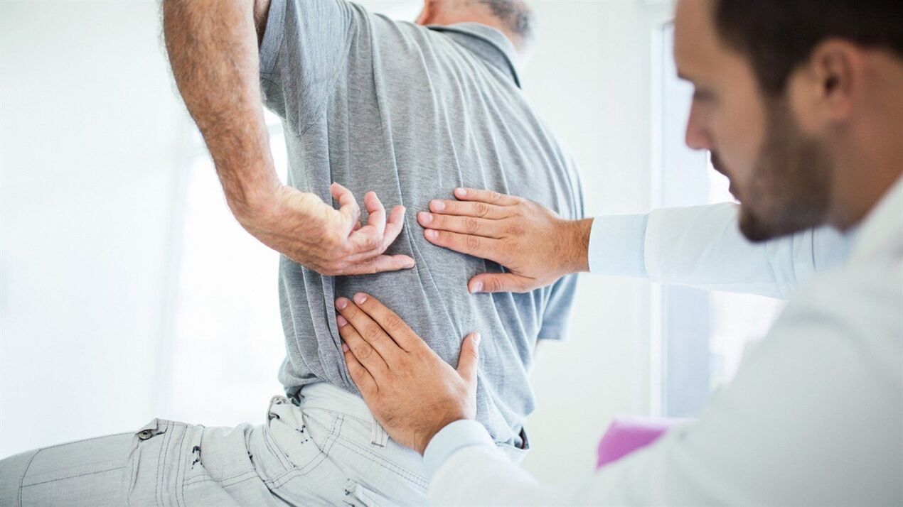 un médecin examine le dos avec une ostéochondrose lombaire